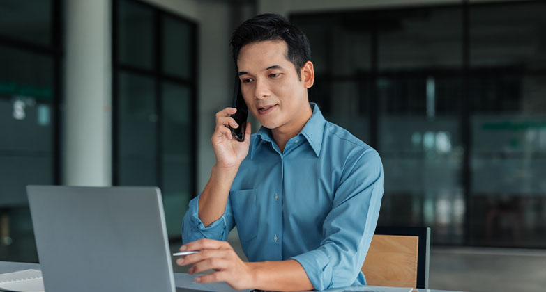 man using computer and phone